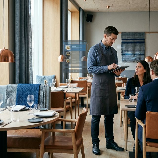 Mesero usando RestauranDev en un restaurante moderno
